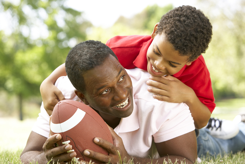 Father And Son In Park With American Football