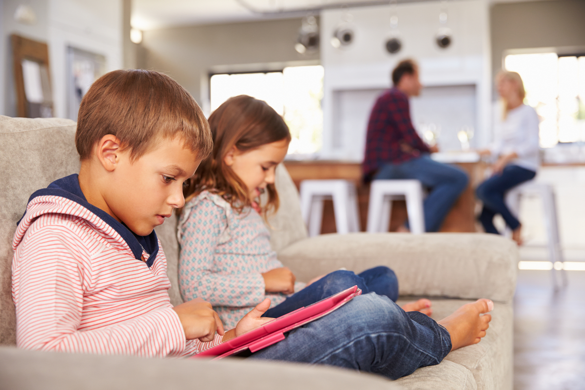 Parents talking while kids playing with technology